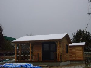 初雪の中のログハウス